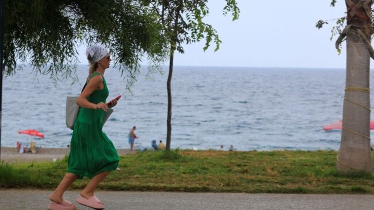  Konyaaltı'nda denizin keyfini çıkartan vatandaşlara yağış sürprizi