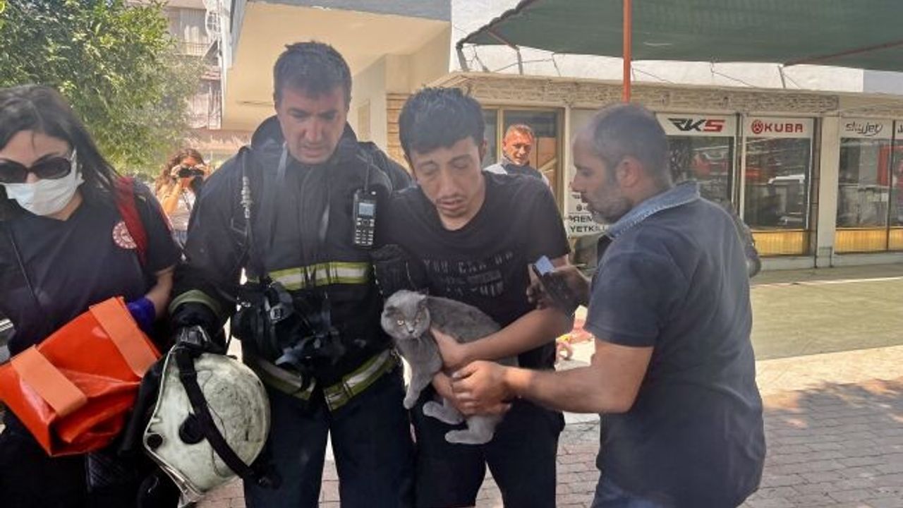  Alevlerin sardığı evde balkona sığındı, kedisini elinden bırakmadı