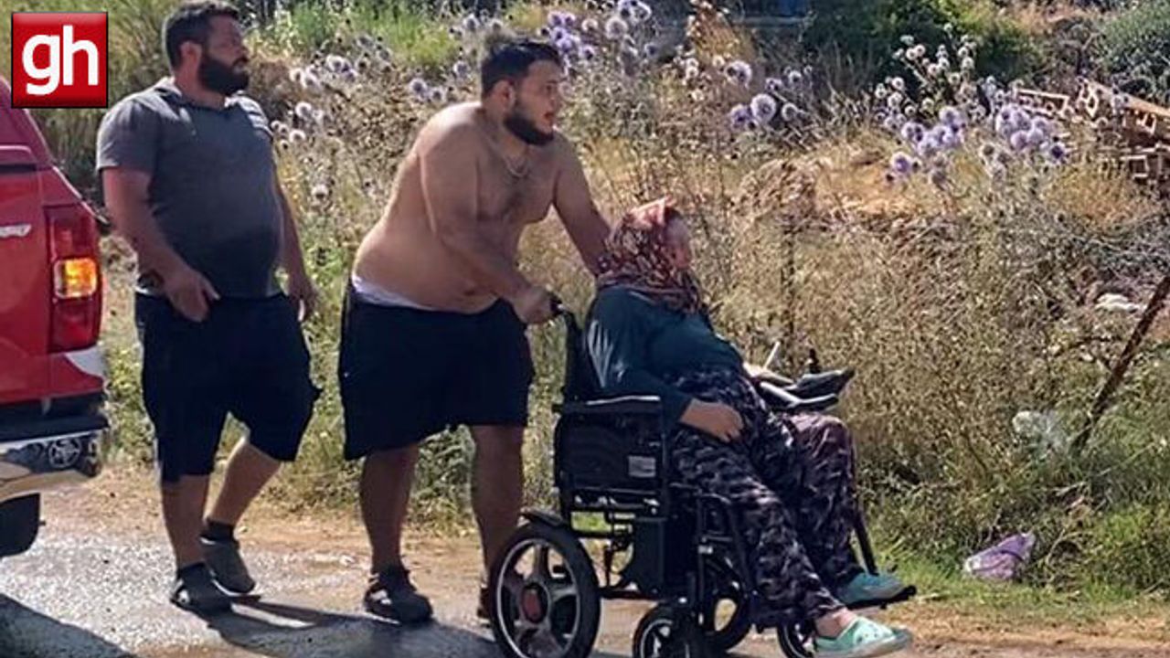 Aksu'da evine yaklaşan alevlerden kurtarılan kadın tekerlekli sandalyeyle bölgeden uzaklaştırıldı