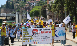 1 Mayıs kutlamalarında yürüyen işçilerle çalışan işçiler aynı karede