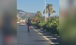 Alanya'da motosiklet üzerinde ayakta ilerleyen sürücünün tehlikeli yolculuğu kamerada