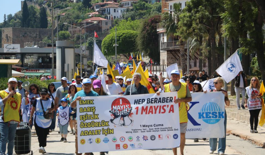 1 Mayıs kutlamalarında yürüyen işçilerle çalışan işçiler aynı karede