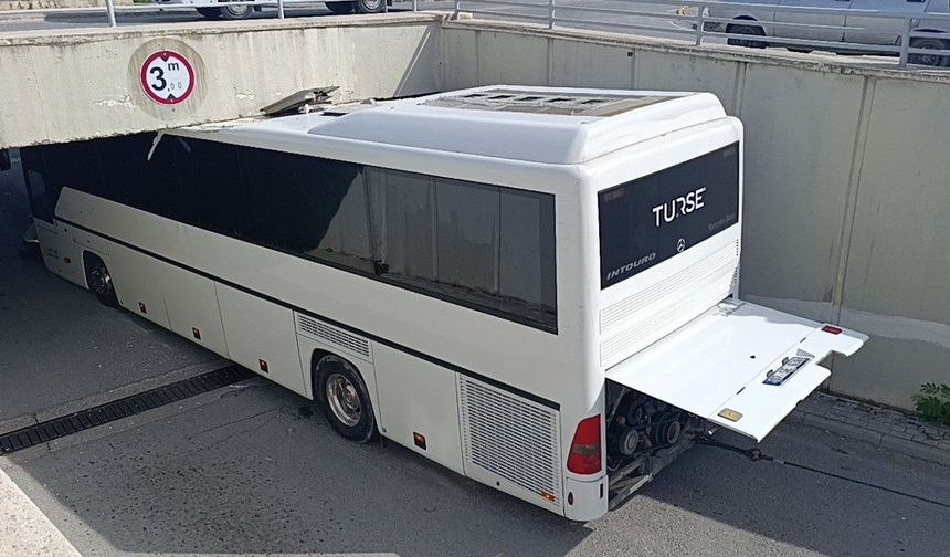 Alt geçide sıkışan tur otobüsünü 2 vinç 3 saatte güçlükle çıkardı