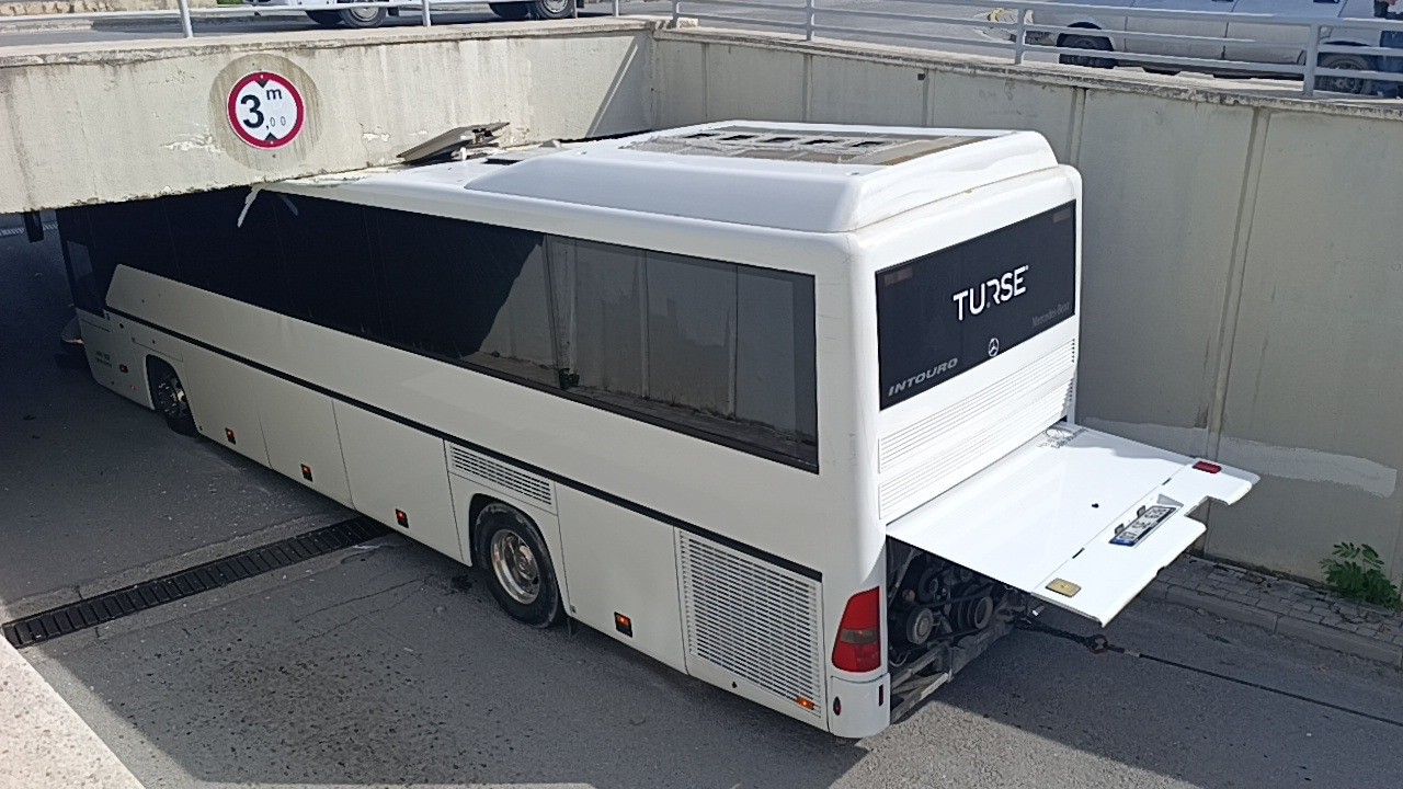 Alt geçide sıkışan tur otobüsünü 2 vinç 3 saatte güçlükle çıkardı
